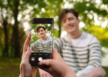Fotografia de una persona dentro del encuadre del celular con fondo verde