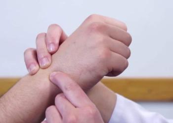 Fotos de una persona señalando la muñeca en la mano de un tercero