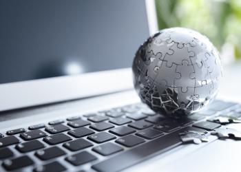 Foto de una mundo armado con piezas de rompecabezas color gris sobre un teclado