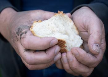 Imagen de una persona con un pan en la mano.