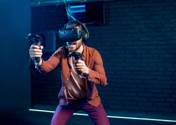 Hombre jugando con gafas de realidad aumentada con un fondo azul