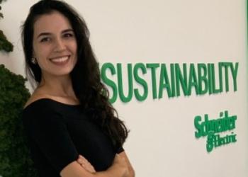 Foto de una mujer posando al frente de un logo de Schneider