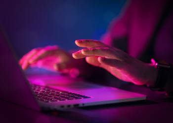 Manos sobre un computador portatil, foto con efecto morado