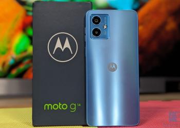 Foto de motorola, celular azul claro con una caja nega de fondo