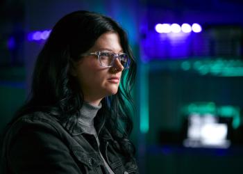 Mujer con gafas de perfil, pelo negro, viendo una pantalla