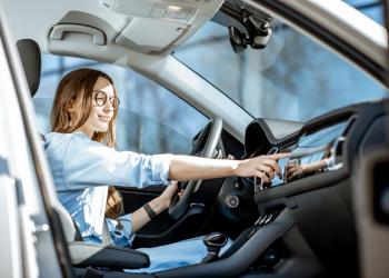 Mujer en el carro cambiando de estación de radio