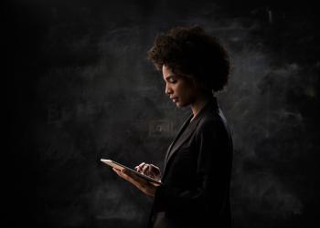Mujer mirando computador con fondo negro