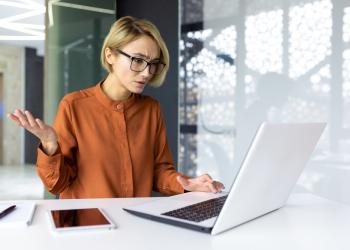 Mujer quejandose al frente de un computador