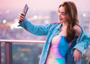 Mujer tomándose una fotografía con un fondo de ciudad