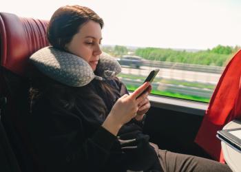 Una mujer viaja en una flota mientras revisa su celular