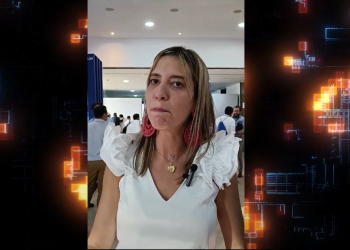 Fotografía de una mujer mona con blusa blanca hablando a la cámara
