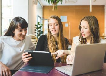 Mujeres reunidas en una mesa compartiendo ideas