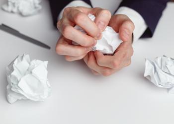 Una persona arrugando un papel