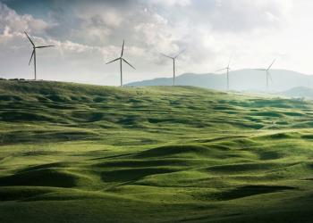 Foto de campo verde con tecnología eólica