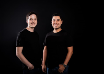 Foto de dos hombres con camiseta negra sonriendo a la cámara