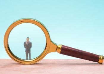 Una lupa con la figura de un hombre adentro del lente