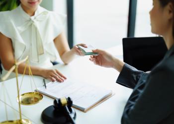 Una mujer realizando un pago a otra mujer