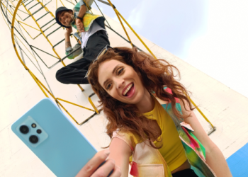 Fotografía de una persona sosteniendo un celular en la mano derecha de color azul