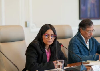 Foto de una mujer con sentada con un micrófono al frente