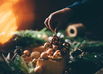 Foto de una foto de navidad, de una persona poniendo una bola de navidad en un canasto