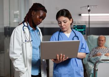 foto de un hombre y una mujer mirando un computador en una sala médica