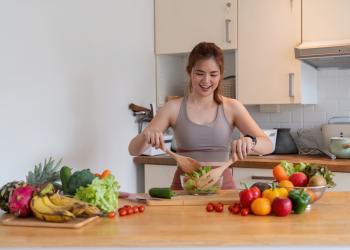 foto de una mujer preparando una receta con varias frutas al rededor