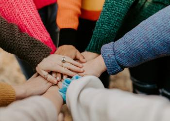 foto de varias personas poniendo su mano en el centro