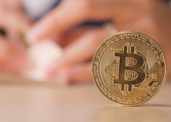 moneda cipto sobre una mesa con dos manos de fondo