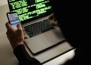 persona con su laptop y un celular
