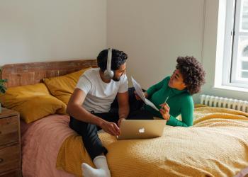 Dos personas en cama con una laptop