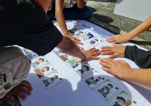 Imagen de niños juntando sus manos en una cartulina