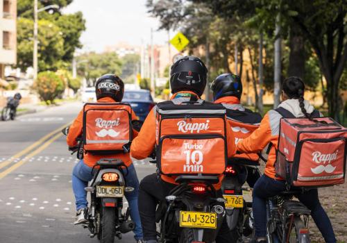 Personas en motos haciendo delivery