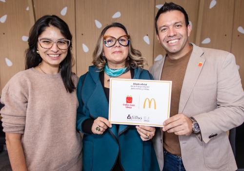 Foto de tres personas, dos mujeres y un hombre posando para la cámara