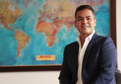 foto de un señor sonriendo a la cámara con un mapa de fondo