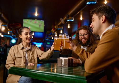 Amigos mirando un partido de futbol y tomando cerveza