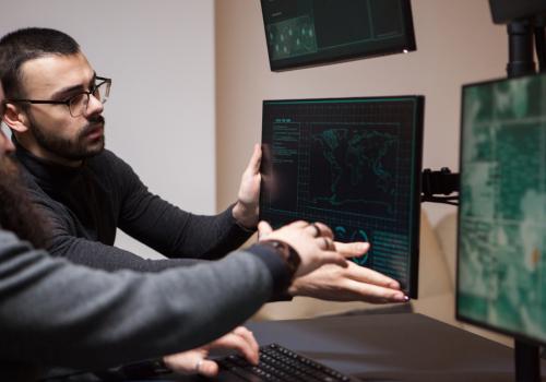 Foto de dos personas mirando una pantalla