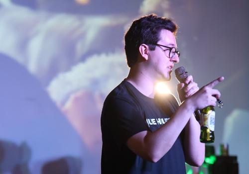 Foto de un hombre hablando con una cerveza en la mano