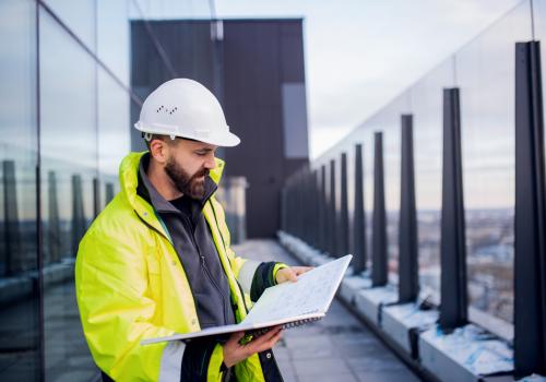 Constructor mirando planos en una terraza