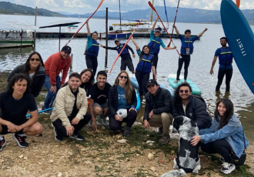 Foto devarias personas reunidas y mirando a la cámara con un lago de fondo