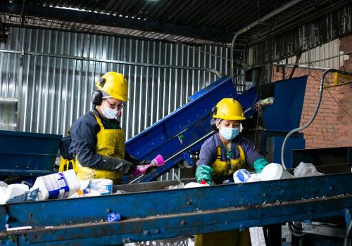 Representación de dos trabajadoras reciclando en una fábrica 