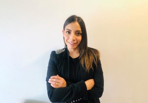 Foto de una mujer con blazer negro mirando a la cámara