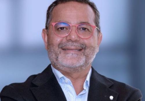 Foto de un profesional con gafas rojas mirando a la cámara