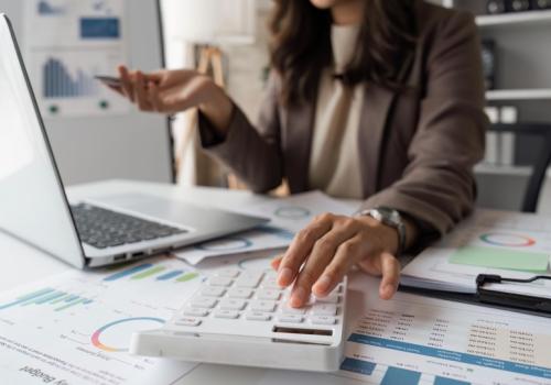 Foto de la mano de una mujer cuadrando las finanzas de una compañía