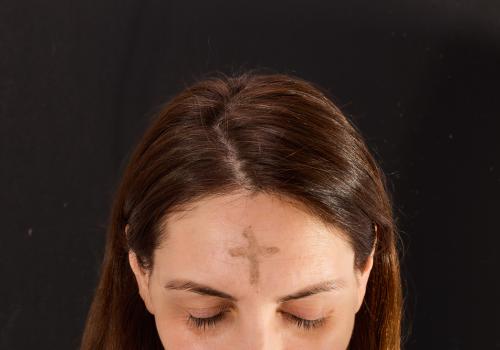 Foto de mujer con una cruz en la frente