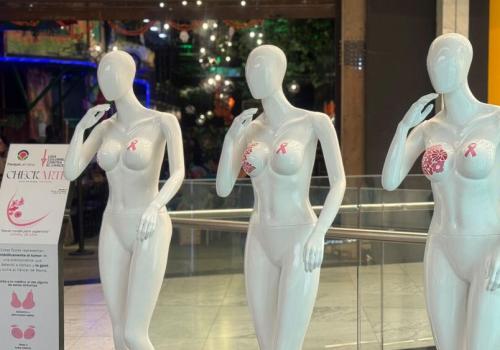 Foto de tres maniquies blancos con figuras rosadas