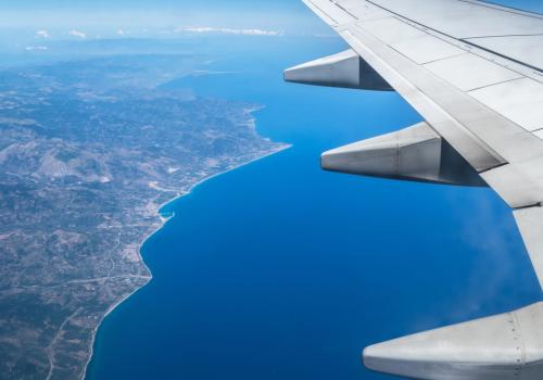 Foto de un ala de un avión y debajo la tierra y el mar