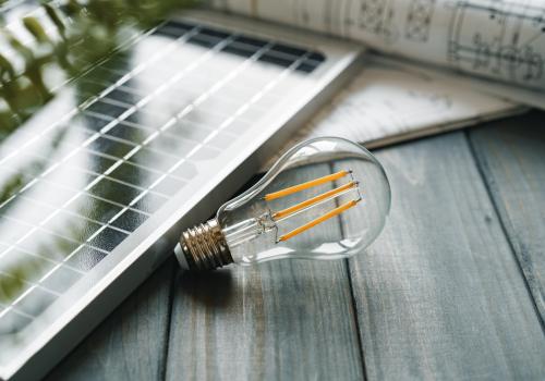 Foto de un bombillo con un panel de energía solar al lado