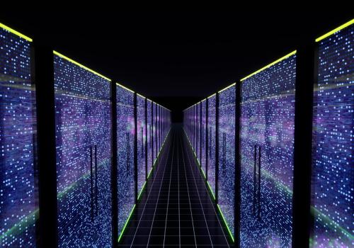 Foto de un centro de datos desde adentro con luces de colores que contastan con la oscuridad