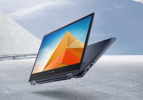 Foto de un computador con la pantalla entreabierta con un fondo gris
