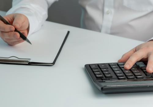 Foto de un hombre con una calculadora y una hoja de papel